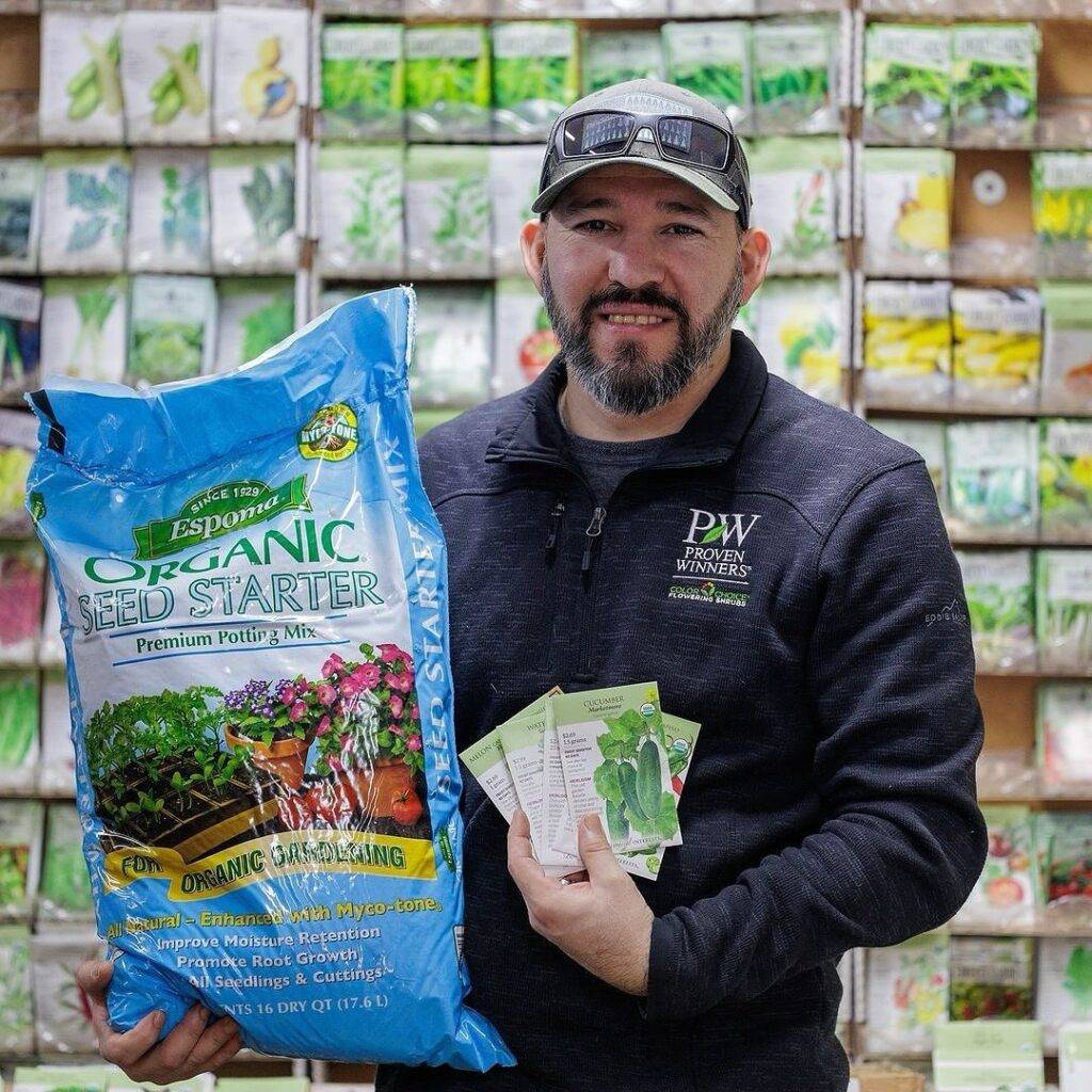 man carrying a bag of espoma seed starter potting mix