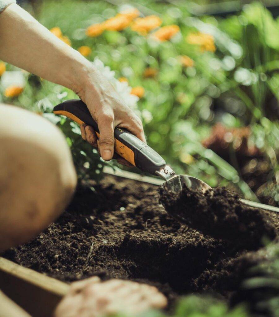 digging a hole in a garden bed with a fiskars garden trowel